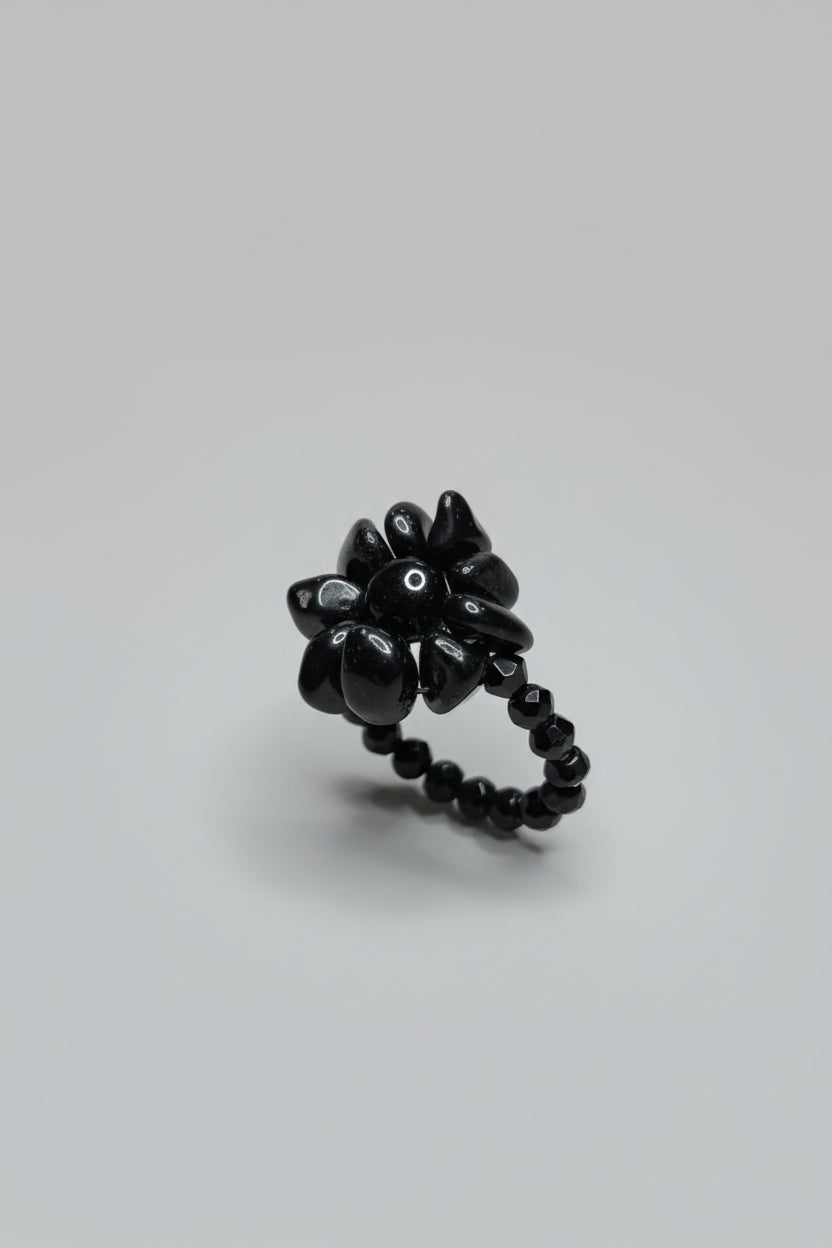 Anillo elástico flor con piedra chip turmalina y cuentas cristal nego( Diseño de Lubelia)