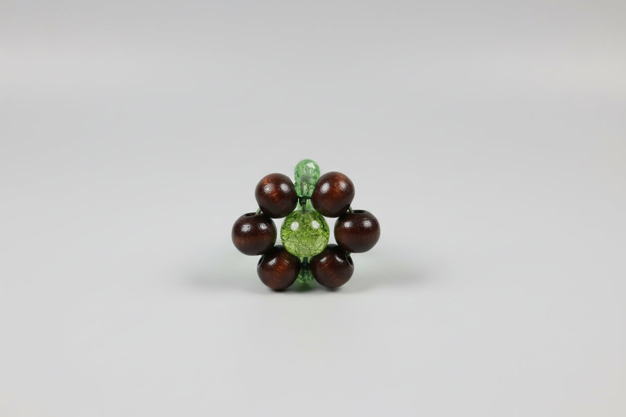 Anillo elástico flor de madera y cuenta verde (Diseño de Lubelia ) IVA incluido.