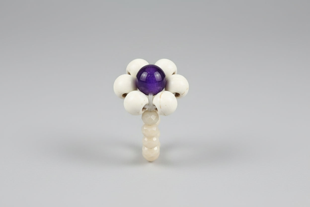 Anillo elástico flor de madera, cristales de color hueso y cuenta violeta (Diseño de Lubelia )IVA incluido.
