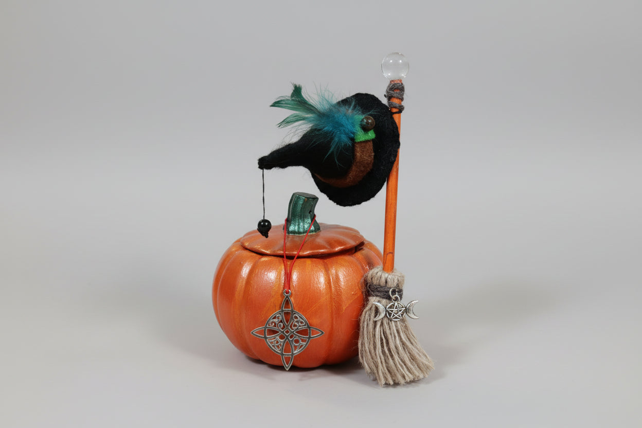 Calabaza con sombrero pluma azul y escoba más nudo de bruja de acero 7X9cm.( Diseño de Lubelia)IVA incluido.