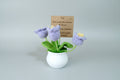 Macetero  blanco con flor violeta. de Crochet. Lleva un cartelito con mensaje. 10X5cm.IVA incluido.