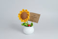 Macetero  blanco con flor girasol de crochet. Lleva un cartelito con mensaje. 13X5cm.IVA incluido.