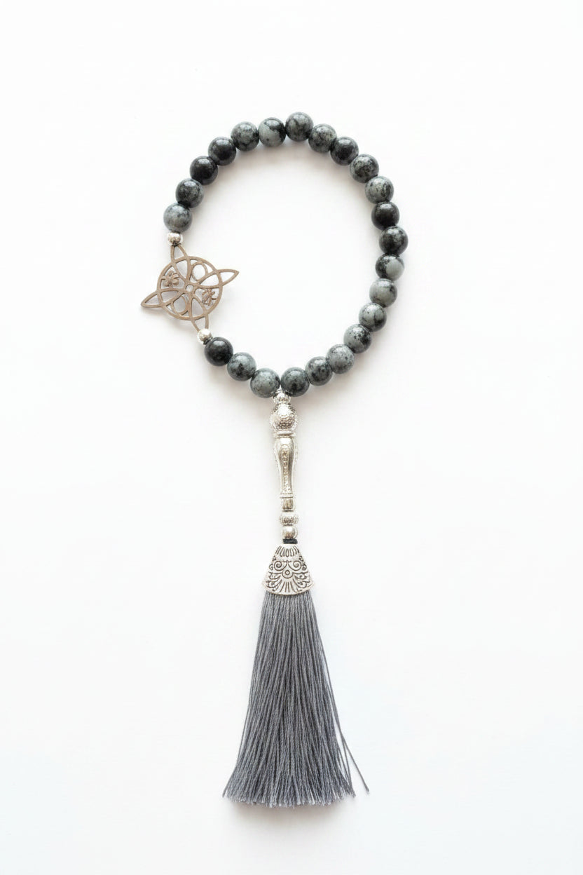 Colgador para el móvil con nudo de bruja y borla color gris. IVA incluido.