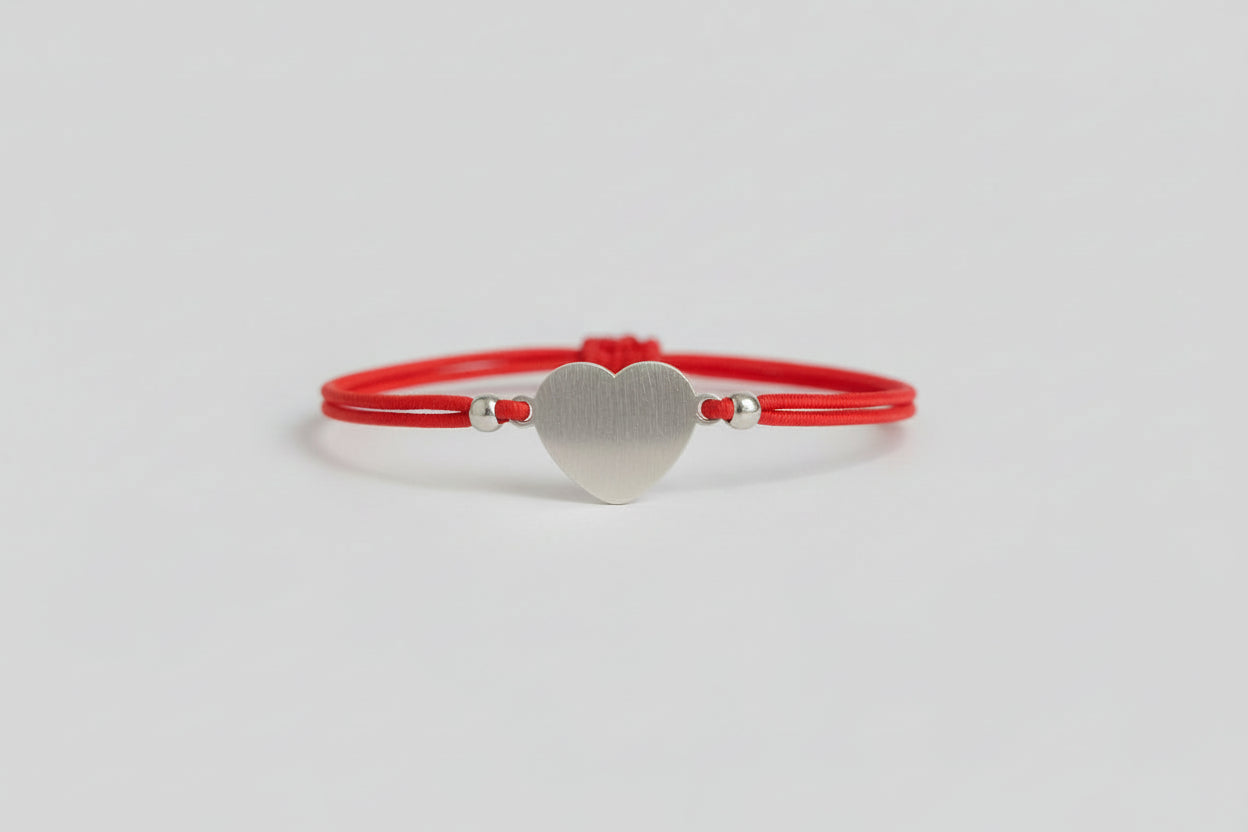 Pulsera elástica roja con amuleto corazón a cero. IVA incluido